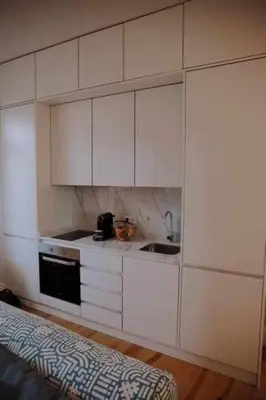 a kitchen with white cabinets and a sink at Porto Apartments in Porto