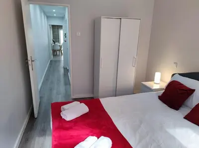 a bedroom with a large white bed with a red blanket at Torre dos Clérigos Apartment in Porto