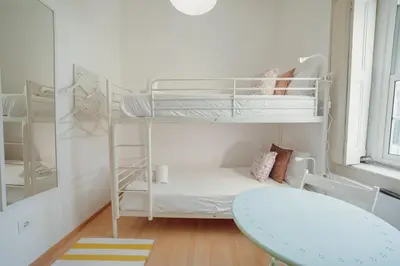 a room with two bunk beds and a table at Moinho de Vento Studios in Porto