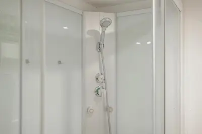 a white bathroom with a toilet and a shower at Moinho de Vento Studios in Porto