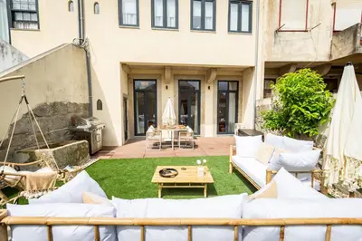 a patio with white couches and a table at OPO Vale Formoso II Garden & BBQ in Porto