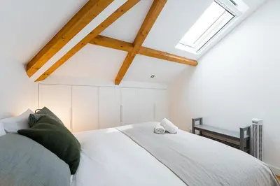 a bedroom with a white bed with a skylight at GuestReady - Freixo Paradise view in Porto