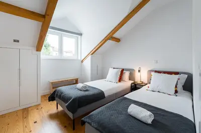 two beds in a room with a window at GuestReady - Freixo Paradise view in Porto