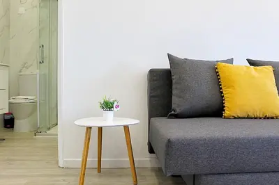a living room with a couch and yellow pillows at Plano C 2 Oporto Downtown in Porto