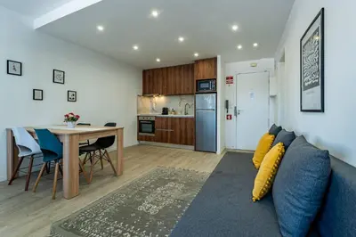 a living room with a couch and a table and a kitchen at Plano C 2 Oporto Downtown in Porto