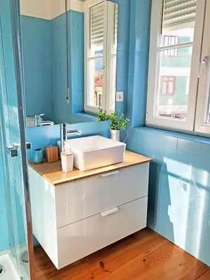a bathroom with a white sink and blue walls at Cozy 3 room apartment near House of Music in Porto