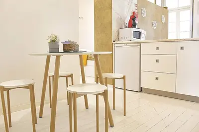 a table and two stools in front of a door at Benskins Loft Oporto Downtown in Porto