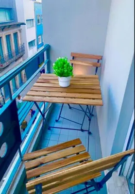 a wooden table with a potted plant on a balcony at Charmant appartement climatisé avec balcons in Porto