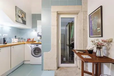 a kitchen with a washing machine and a table at Design Poveiros Duplex in Porto