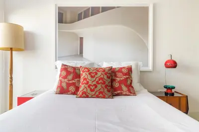 a bedroom with a white bed with red pillows at Design Poveiros Duplex in Porto