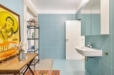 a bathroom with blue tiles and a sink at Design Poveiros Duplex in Porto