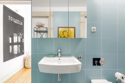 a bathroom with a white sink and blue tiles at Design Poveiros Duplex in Porto