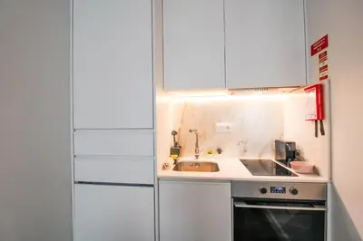 a small kitchen with a sink and a refrigerator at Heroísmo Cosy Loft in Porto