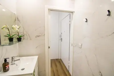 a white bathroom with a sink and a shower at Heroísmo Cosy Loft in Porto