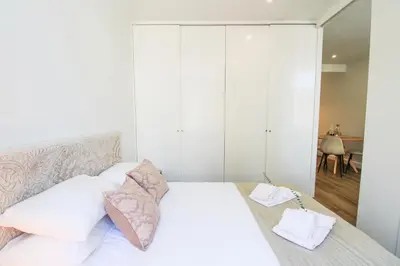 a bedroom with a bed with white sheets and pillows at Heroísmo Cosy Loft in Porto