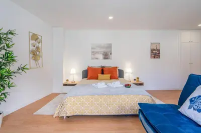 a bedroom with a bed and a blue couch at Host Wise - Comfy Sunny Flat - Prime Location in Porto
