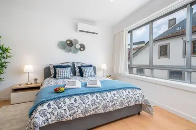 a bedroom with a bed and a large window at Host Wise - Comfy Sunny Flat - Prime Location in Porto