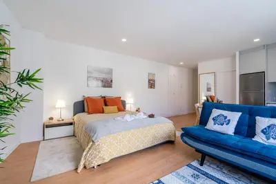 a bedroom with a bed and a blue couch at Host Wise - Comfy Sunny Flat - Prime Location in Porto
