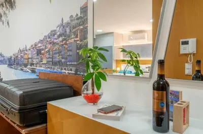 a bottle of wine sitting on a table next to a window at 24 Porto Novíssímo Estudio em Cedofeita AC Olive in Porto
