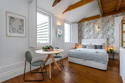 a bedroom with a bed and a table and chairs at GuestReady - Beer Garden in Porto