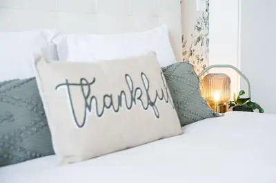 a thankful pillow on a white couch with pillows at GuestReady - Beer Garden in Porto