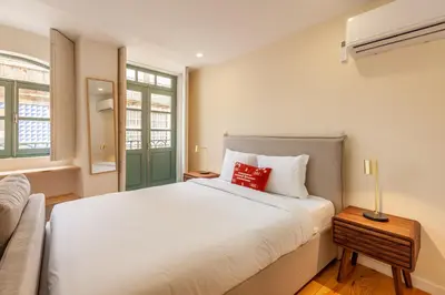 a bedroom with a large white bed with a red pillow at Dasi House in Porto