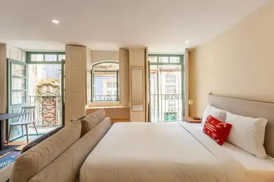 a bedroom with a large white bed with a red pillow at Dasi House in Porto