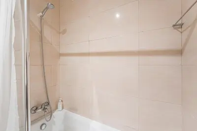 a shower with a glass door and a tub at GuestReady - Casa da Música Cosmopolitan Comfort in Porto
