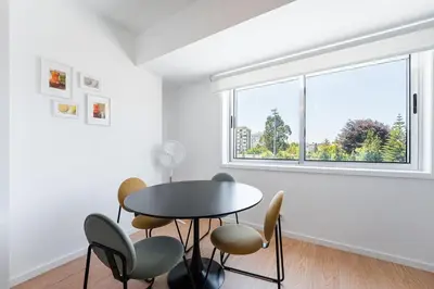 a dining room with a table and chairs and a window at GuestReady - Casa da Música Cosmopolitan Comfort in Porto
