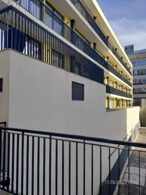 a building with a black railing next to a building at 25 Porto Novíssímo Estudio em Cedofeita AC Olive in Porto
