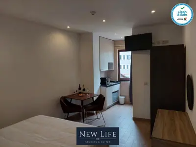 a room with a bed and a kitchen with a table at New Life - TORRE CLÉRIGOS STUDIO-3T in Porto