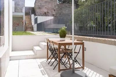 a table on a balcony with a potted plant on it at Porto Grandeur Collection - D. João IV Pool & Garden Apartment in Porto