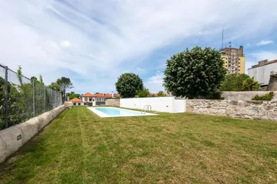 a yard with a fence and a swimming pool at Porto Grandeur Collection - D. João IV Pool & Garden Apartment in Porto