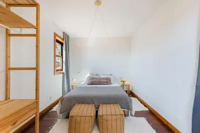 a bedroom with a bed with two brown stools at Hey Apartments A in Porto