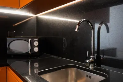 a kitchen with a sink and two faucets at GuestReady - Sedona lodge near Palácio de Cristal in Porto