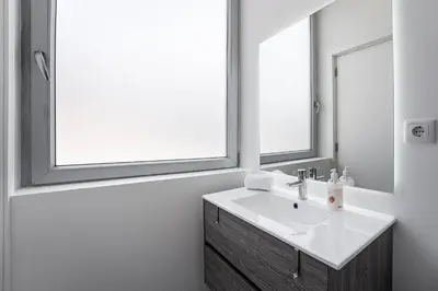 a bathroom with a sink and two windows at GuestReady - Sedona lodge near Palácio de Cristal in Porto