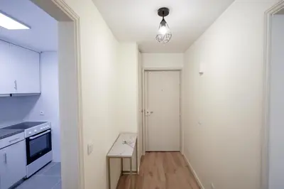 a kitchen with white walls and a hallway with a table at Antero sweet & cozy apartment by PCH in Porto