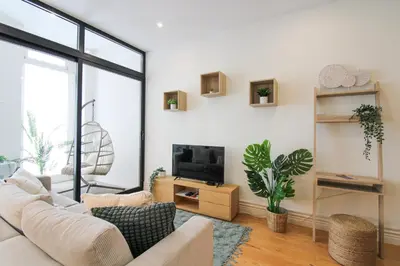 a living room with a white couch and a tv at La Vida in Porto Unique in Porto