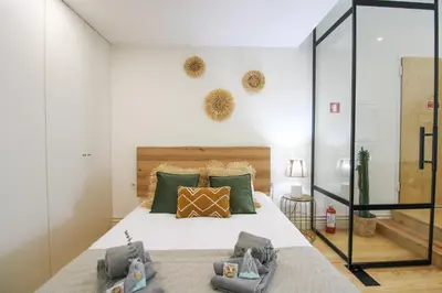 a bedroom with a large bed with green pillows at La Vida in Porto Unique in Porto
