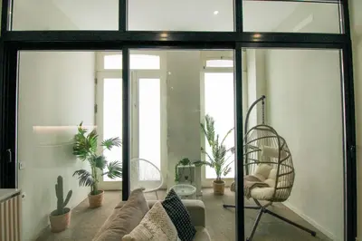 a living room with sliding glass doors and plants at La Vida in Porto Unique in Porto