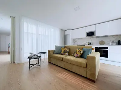 a living room with a couch and a kitchen at Vibrant Host-Campo 24 Agosto in Porto