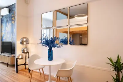 a dining room with a table and chairs and a mirror at Sao Domingos Stylish Apartment in Porto