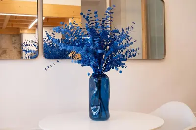 a blue vase filled with blue flowers on a table at Sao Domingos Stylish Apartment in Porto