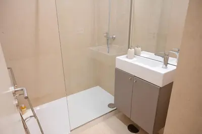 a bathroom with a sink and a glass shower at Sao Domingos Stylish Apartment in Porto