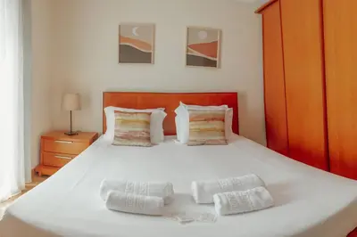 a bedroom with a white bed with two pillows at Bright Apartment by Hosty in Porto