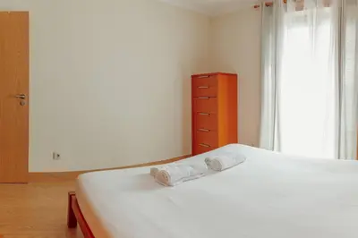 a bedroom with a bed with two towels on it at Bright Apartment by Hosty in Porto