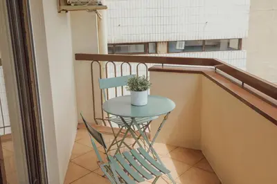 a small table and a chair on a balcony at Bright Apartment by Hosty in Porto