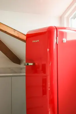 a red refrigerator in a kitchen next to a counter at HM - Home Feeling Studio Campanhã in Porto