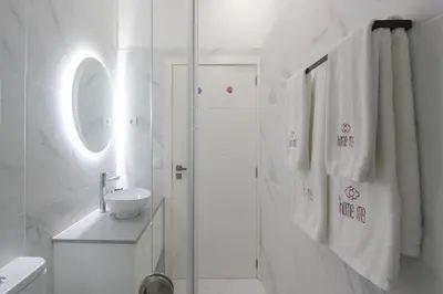 a white bathroom with a shower and a sink at HM - Home Feeling Studio Campanhã in Porto