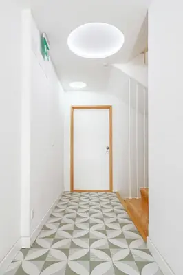 a hallway with a white door and a patterned floor at HM - Home Feeling Studio Campanhã in Porto